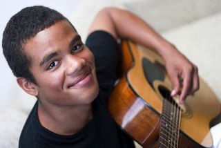 Smiling teenager with guitar