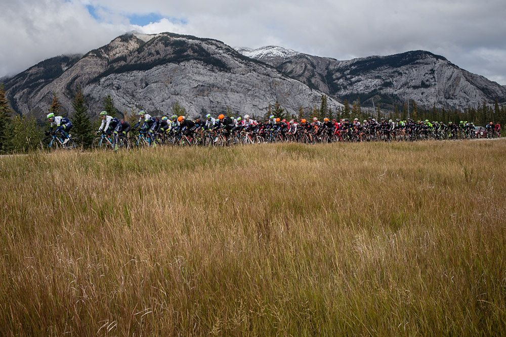 The peloton racing along scenic mountains during stage 3 at the Tour of Alberta