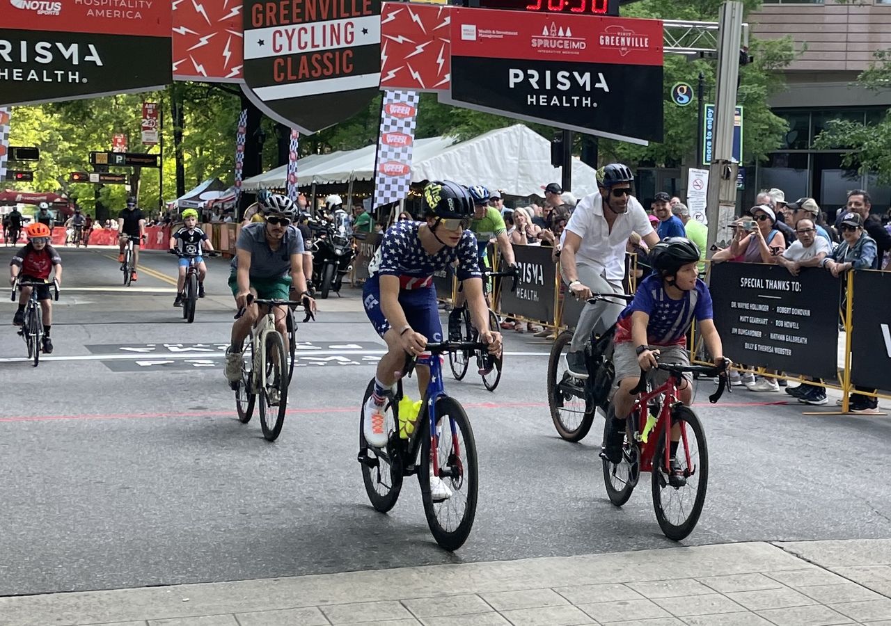 George Hincapie (right) rides a mountain bike in the Tour de France Legends ride along with his son Enzo, sporting the US junior road race champion's jersey