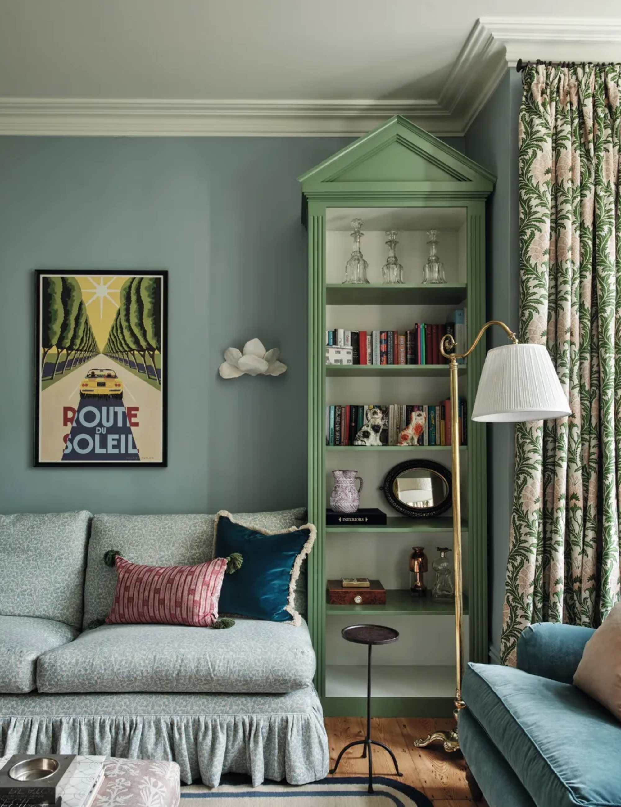 sitting room with blue walls and green painted shelf with arch