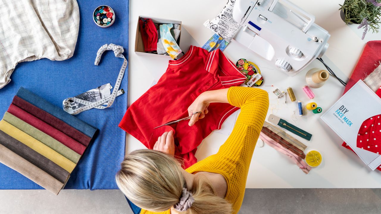 A person cutting clothes and upcycling them