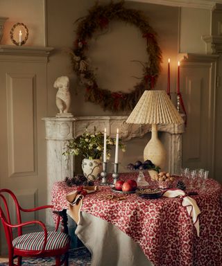 Cozy christmas dining room with large wreath on wall above fireplace