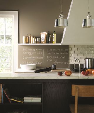 Kitchen wall decor featuring taupe chalkboard paint and marble countertops.