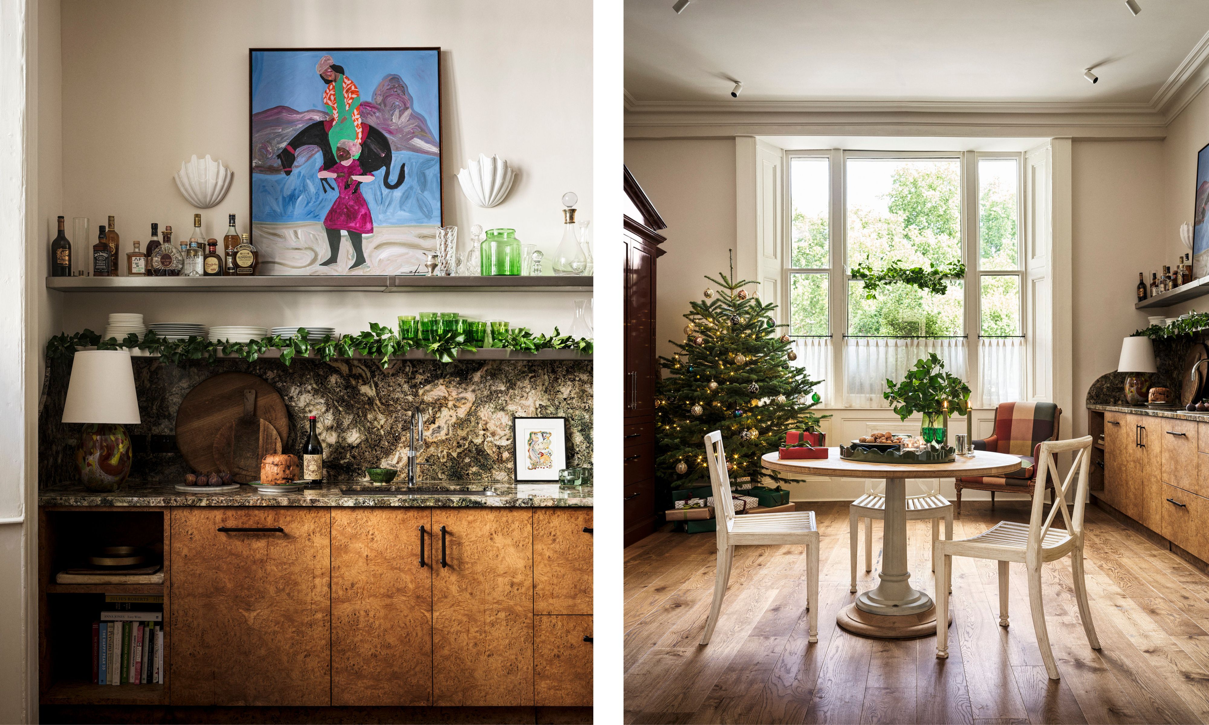 Split image of a kitchen: Left: Counter with burl wood cabinets, stone backsplash, open shelving, and vibrant artwork. Right: Dining area with a round table, white chairs, wood floor, and a Christmas tree near large windows.