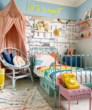 bedroom with blue chair, white bed, cream carpet and patterned rug