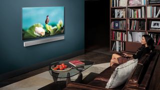 En kvinne sitter i en stue og ser på en Samsung TV.