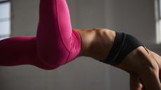 Save with these sports bra deals. Here, a woman doing a yoga pose wearing a sports bra and leggings.