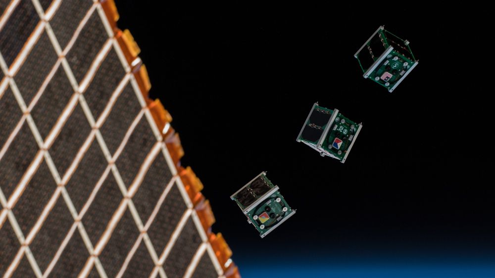 Image of three cubesats being released from the International Space Station