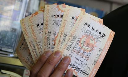 A customer holds $140 worth of Powerball tickets that he just purchased on May 17, 2013 in San Francisco, California.