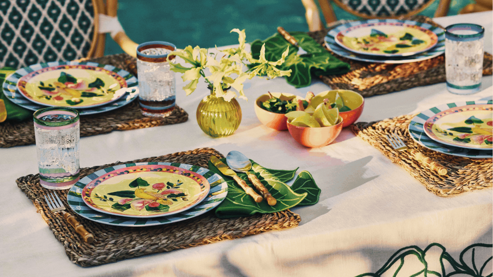 Rotating GIF of three lifestyle images from the Anthropologie x Farm Rio collaboration. Image of a brick bench with colorful pillows, a table set with wicker placemats and colorful plates, and a black tile bar in the outdoors.