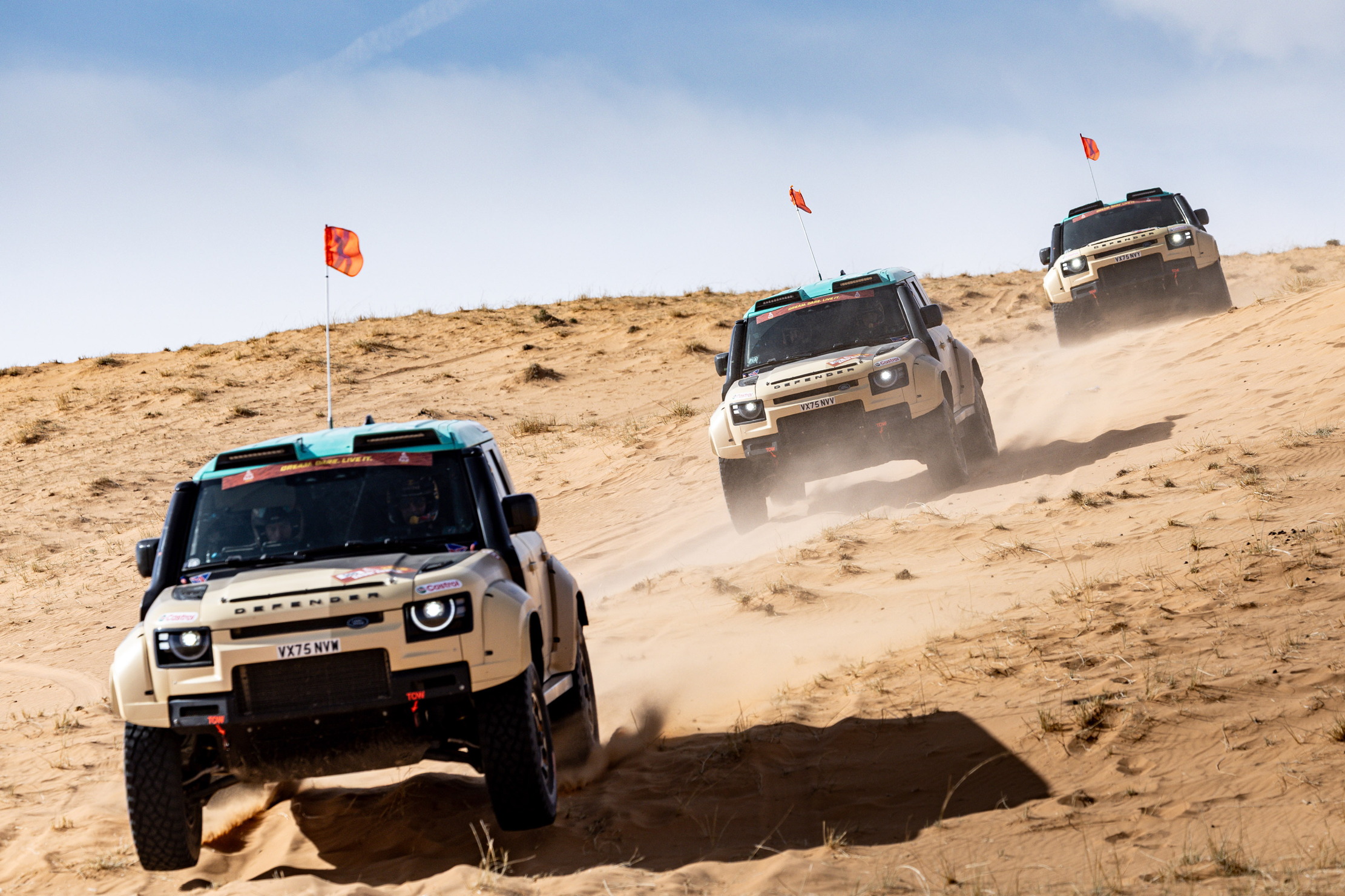 Three Land Rover Defender Octas on a dirt track