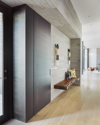 A minimal entryway with wood panelling and built-in bench.