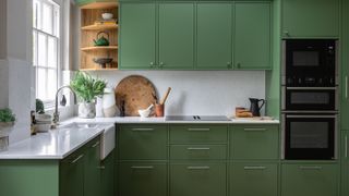 green kitchen cabinets with white worktops