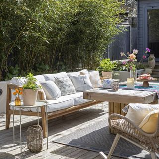 Decking area with cushioned seating, and table with decor items