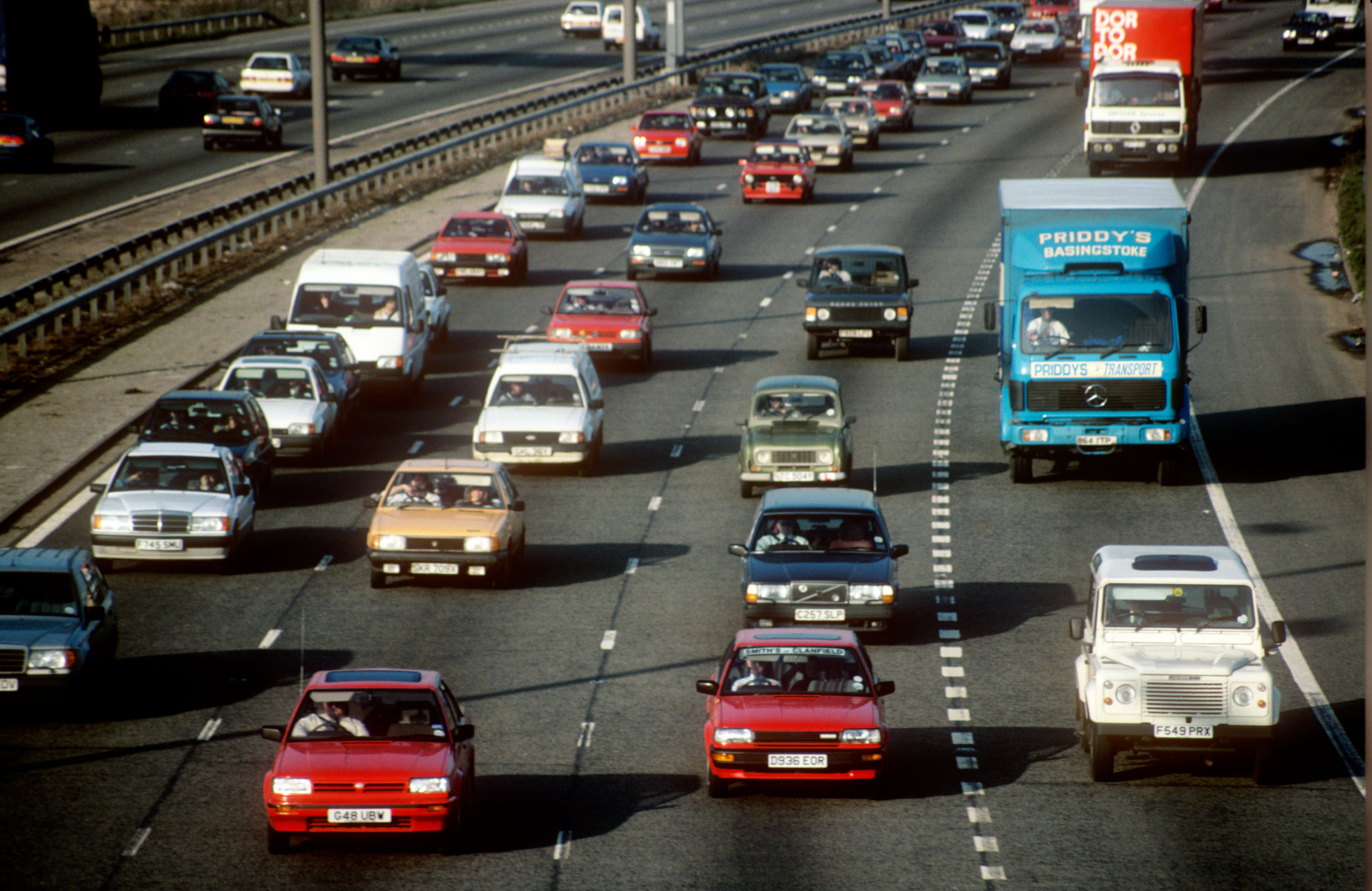 A view of the M25 at Staines in 1990, showing a variety of vintage cars going about their business