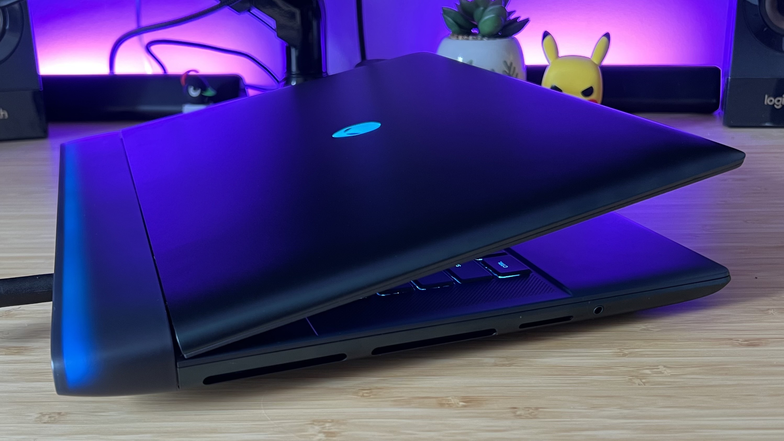 Alienware 16 Area-51 gaming laptop with lid slightly closed on a wooden desk
