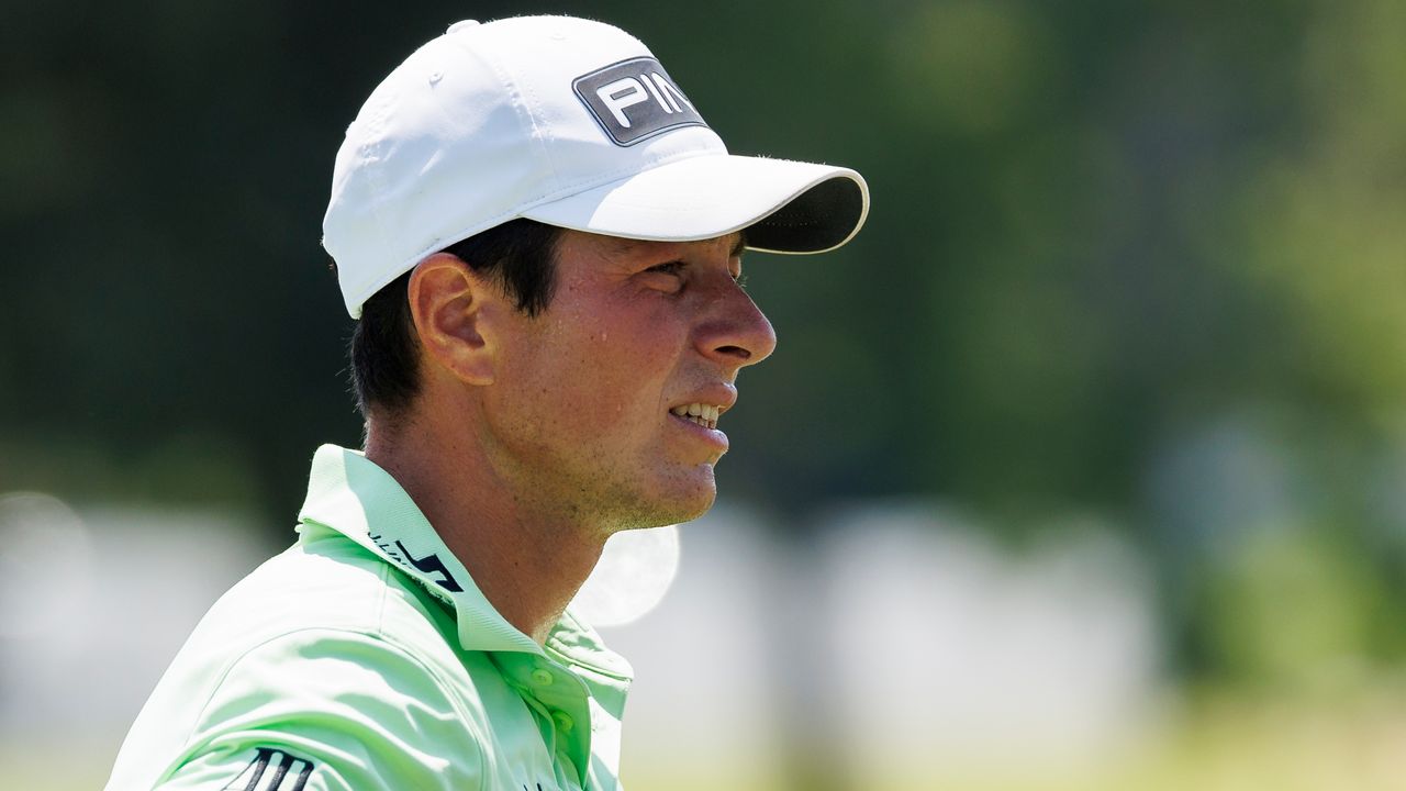 Viktor Hovland wearing a white cap and green polo