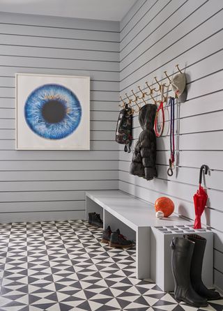 mudroom ideas with grey shiplap walls and monochrome floor tiles