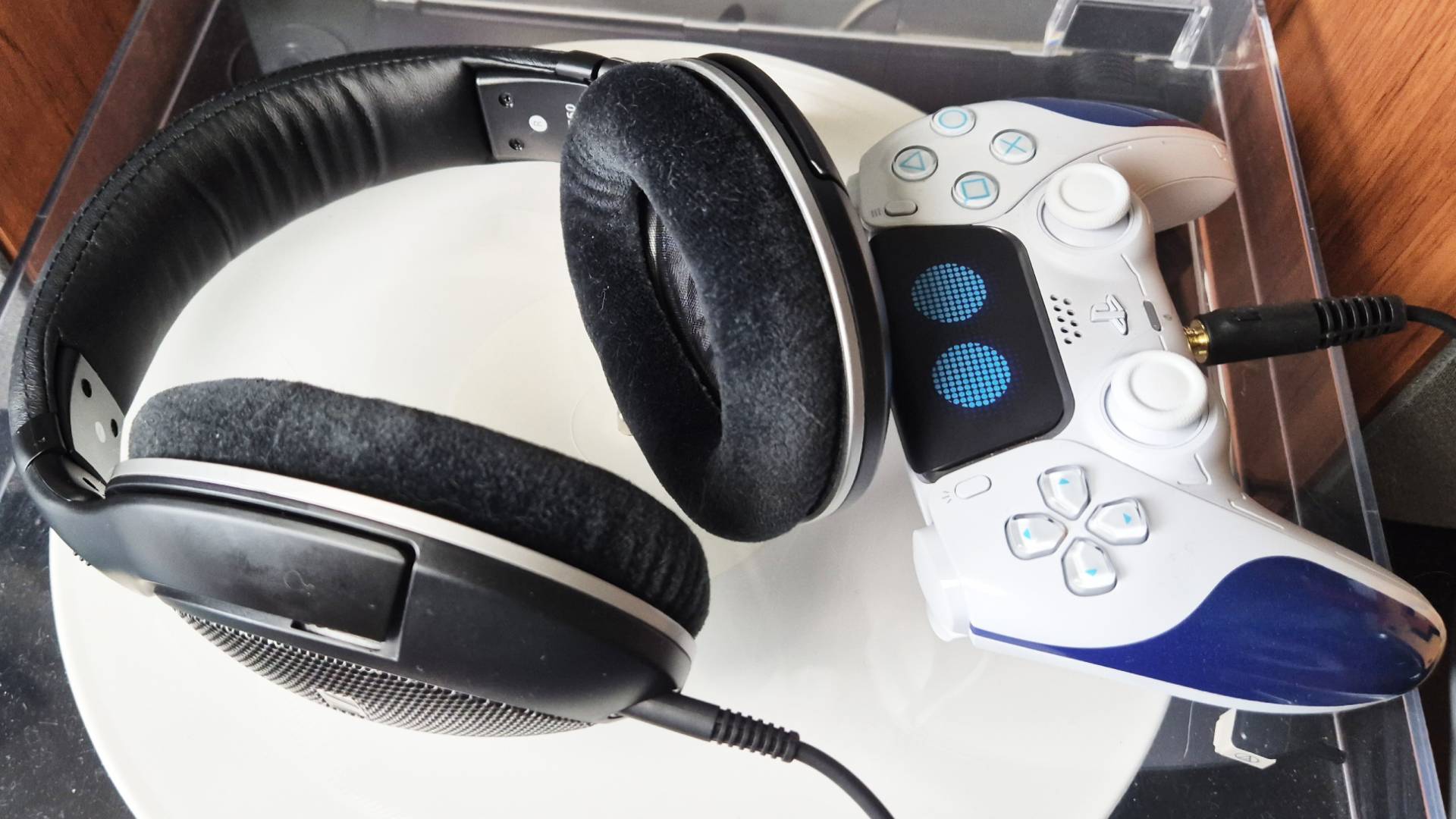 Photo taken by writer Rosalie Newcombe of the Sennheiser HD 550 headphones sitting on a record player, with the PS5 Astro Bot DualSense controller sitting next to it.