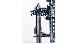 closeup of a large silver spacecraft being stacked atop a silver booster