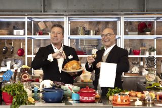 Posed shot of John Torode and Gregg Wallace surrounded by delicious food