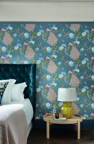 A bedroom with a teal toned wallpaper