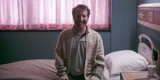 A patient sitting on a bed smiling