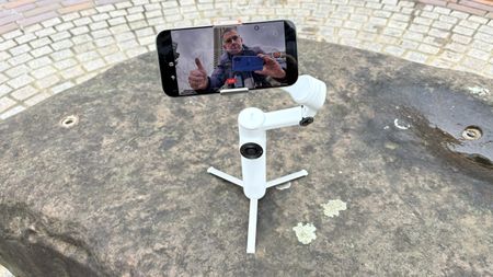 Insta360 Flow 2 Pro gimbal with an iPhone attached sitting on a stone wall