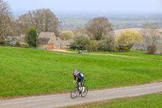 Simon Warren riding along a country lane, open countryside inthe background