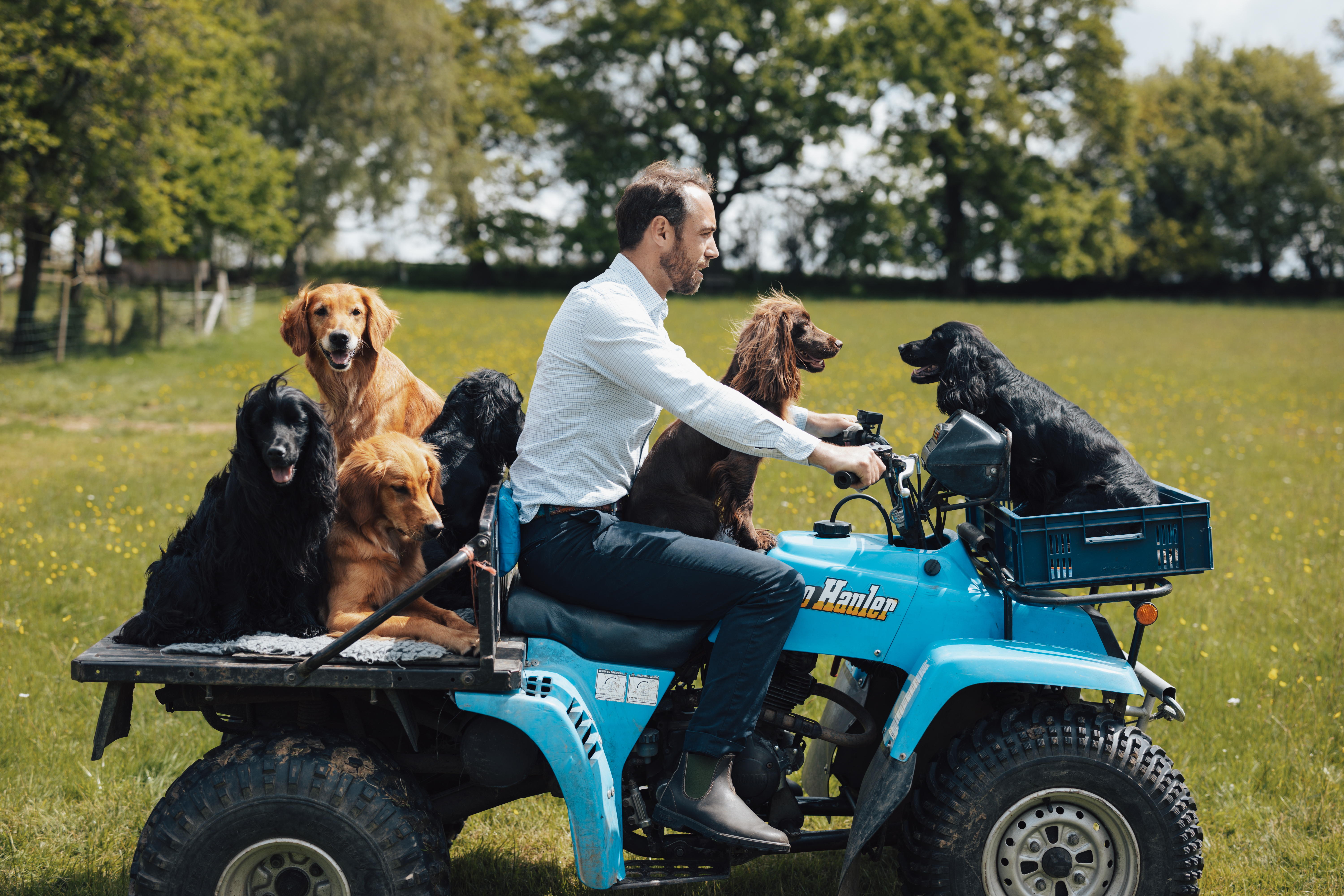 James Middleton on a blue tractor carrying size dogs