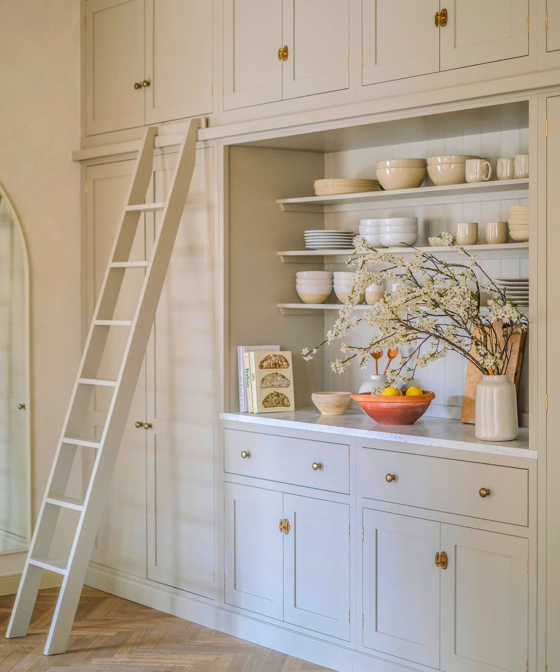 A white kitchen ladder in a white kitchen with open shelving