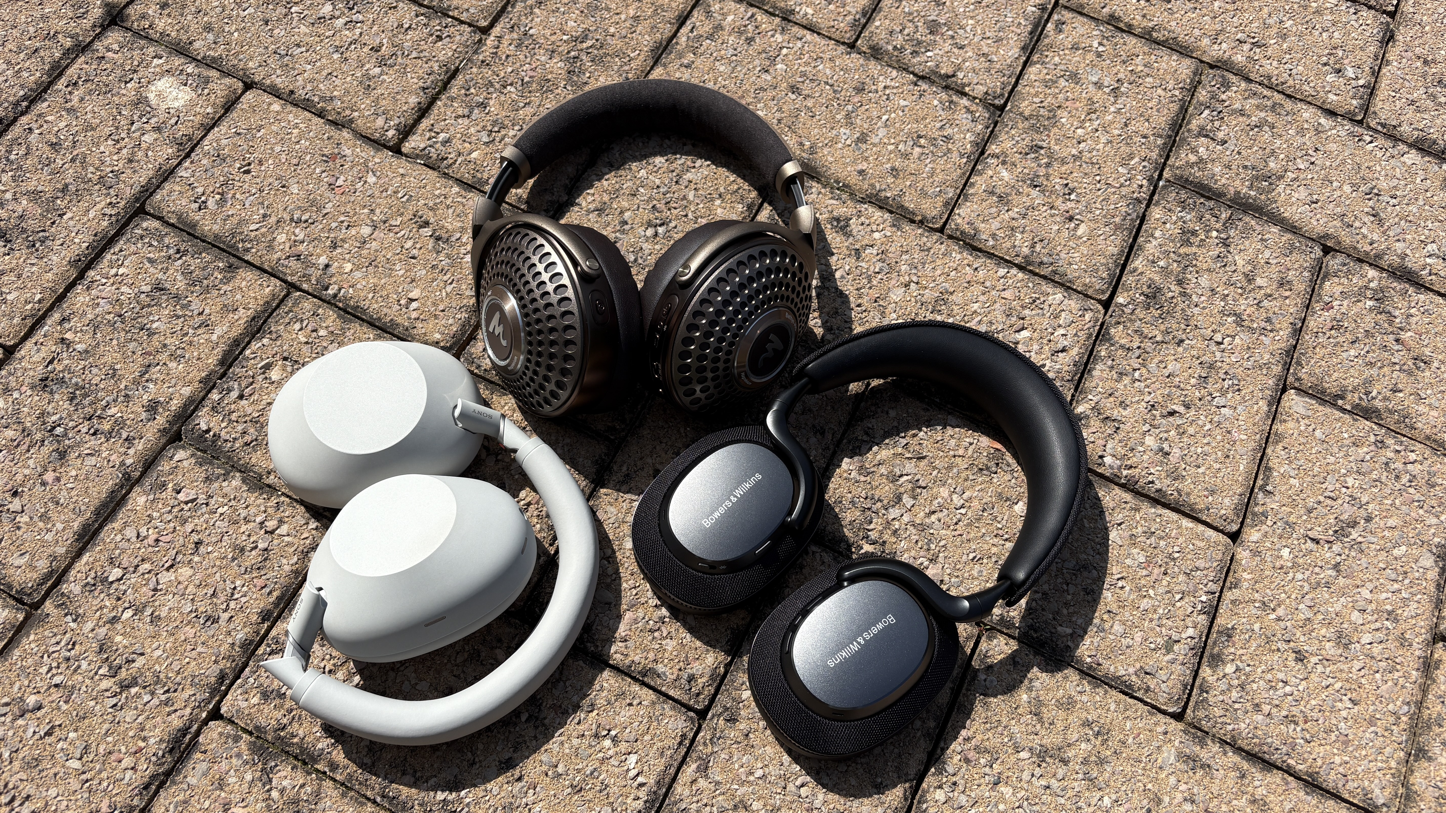 Sony, B&amp;W and Focal headphones on a brick floor 
