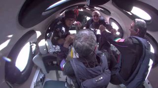 A view inside VSS Unity showing private astronauts floating and looking out the window on June 8, 2024.