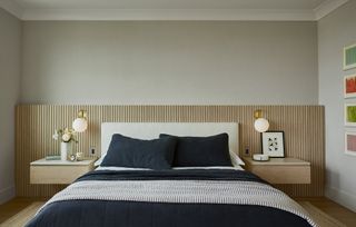Scandinavian style bedroom, with neutral walls and wooden slatted headboard.