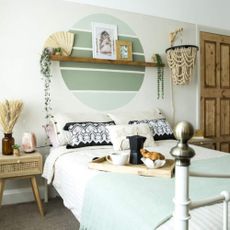 A green bedroom with a serene wall mural