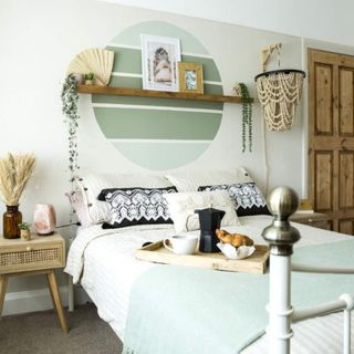 A green bedroom with a serene wall mural