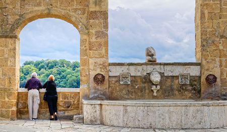 Elderly couple watching the view from the village of Pitigliano, Tuscany