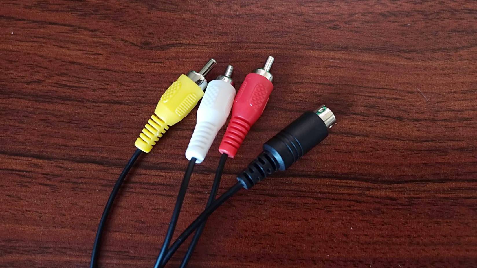 RCA composite cables on woodgrain desk.