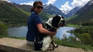 Olly wearing his GPS tracker sat beside Sara in front of lake