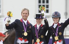 British team on the podium receiving thier medals. L to R Carl Hester, Laura Bechtolsheimer, Charlotte Dujardin