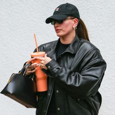 Hailey Bieber wears black leather jacket and white sneakers after pilates class in Los Angeles