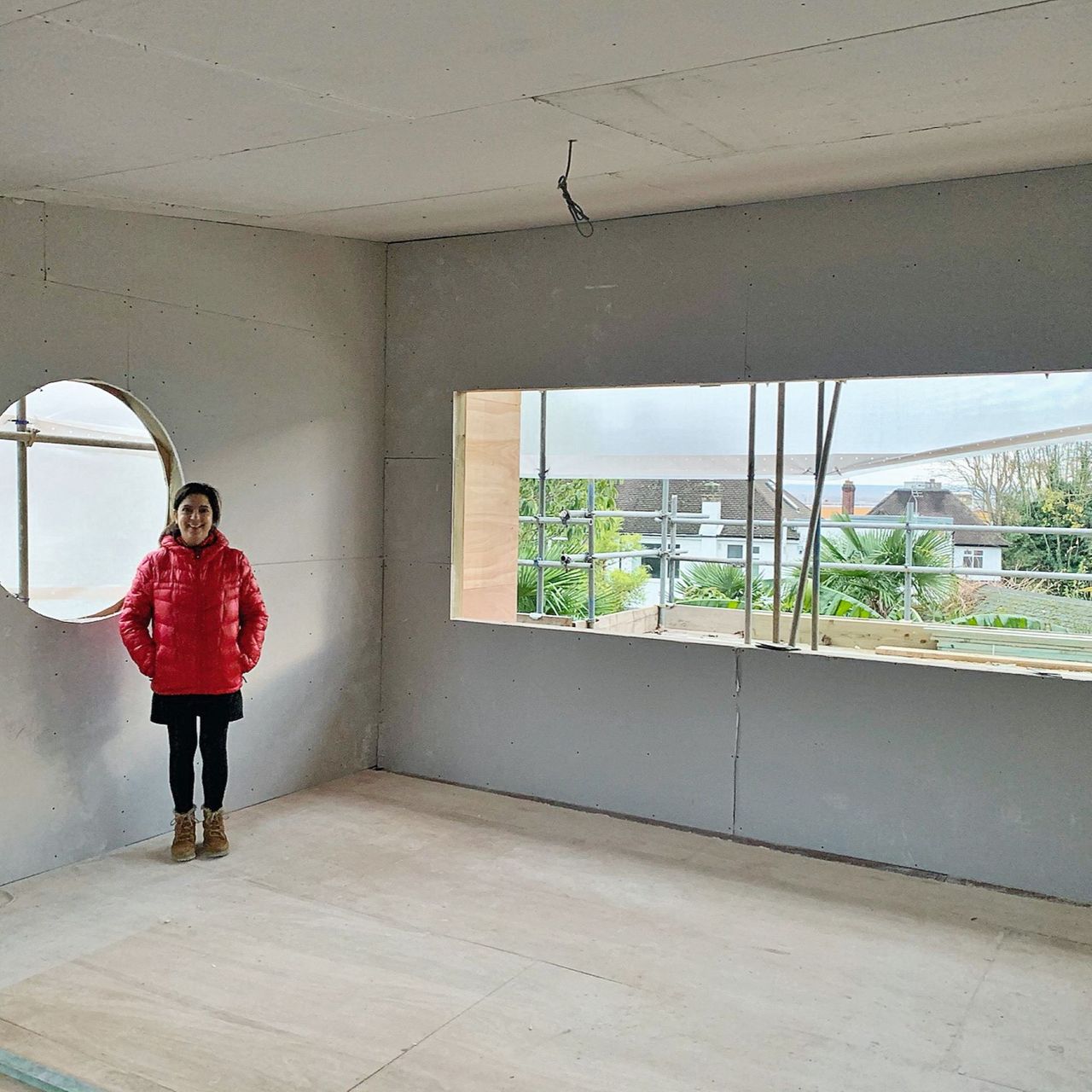 newly plastered bedroom with woman standing in