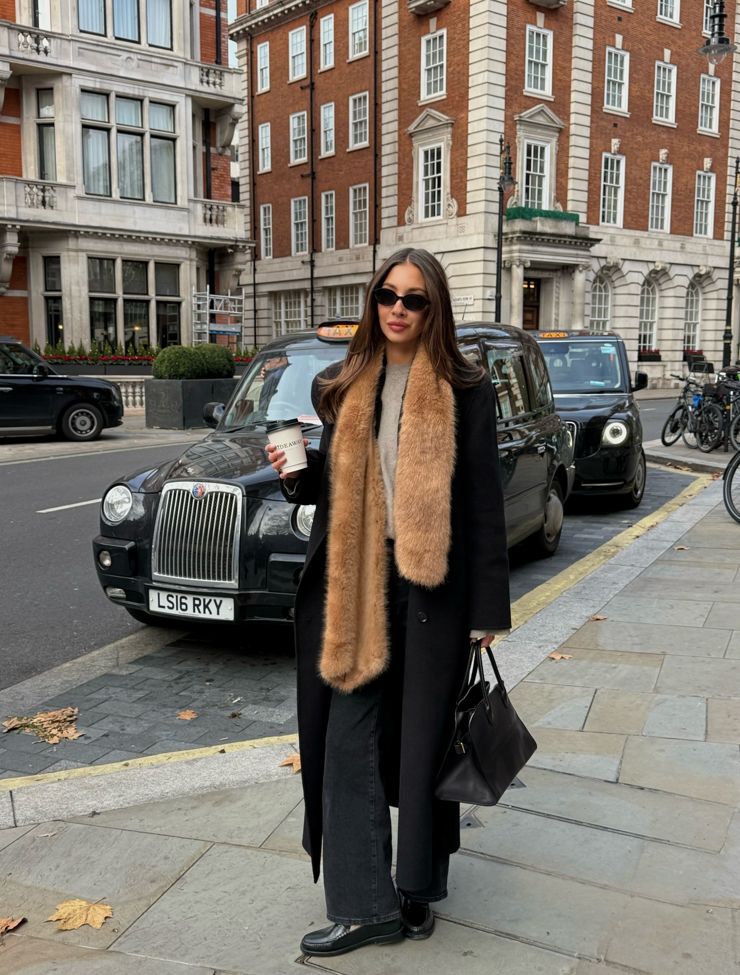 Influencer wearing a faux fur scarf with jeans and loafers.