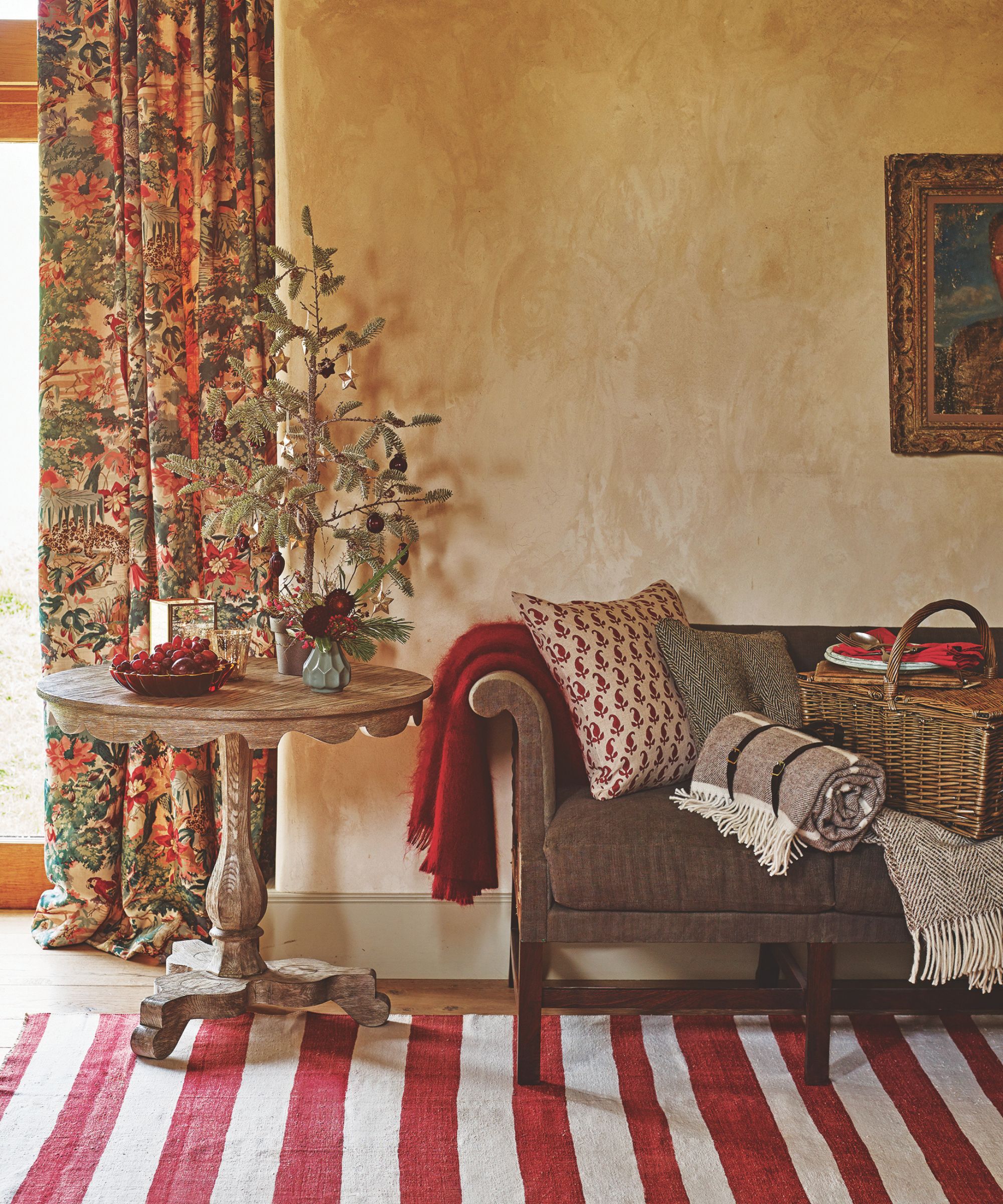Living room with Christmas tree on a side table and red and white stripe rug