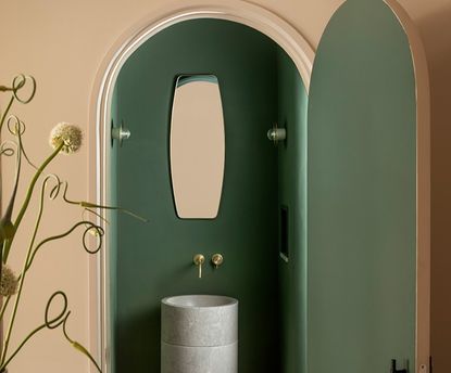 A small bathroom with beige exterior walls and dark green interiors