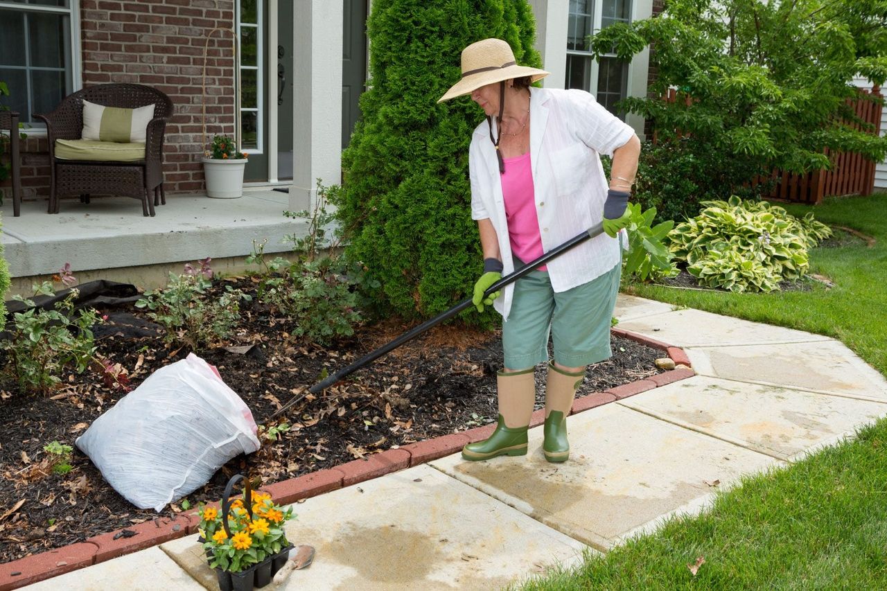 Woman Gardening Infront Of A House