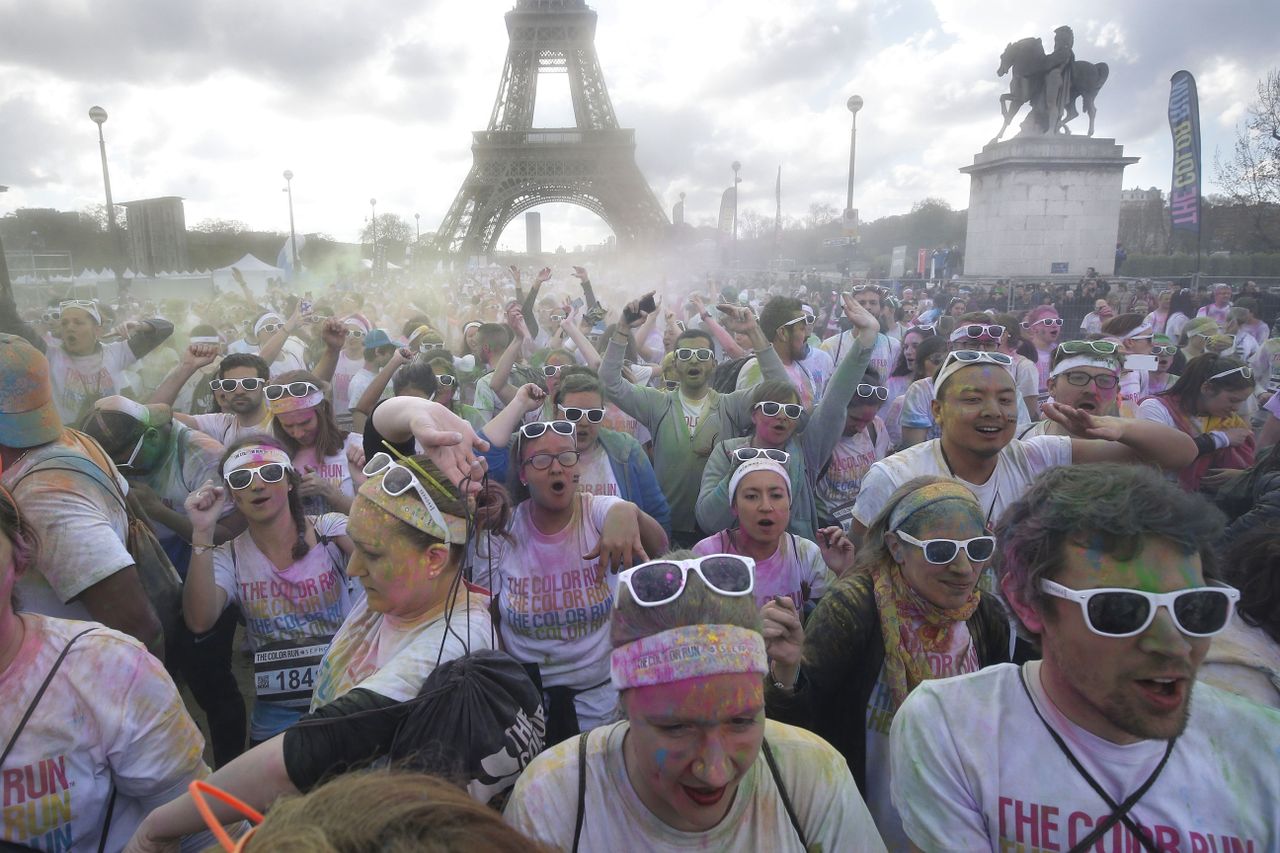 TOPSHOT - People participate in the "Colour Run 2016"in front of the Eiffel Tower in Paris on April 17, 2016. The Colour Run is a five kilometres paint race without winners nor prizes, while