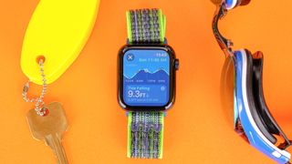 Apple Watch SE 2022 on an orange table with the new Tides app screen displayed