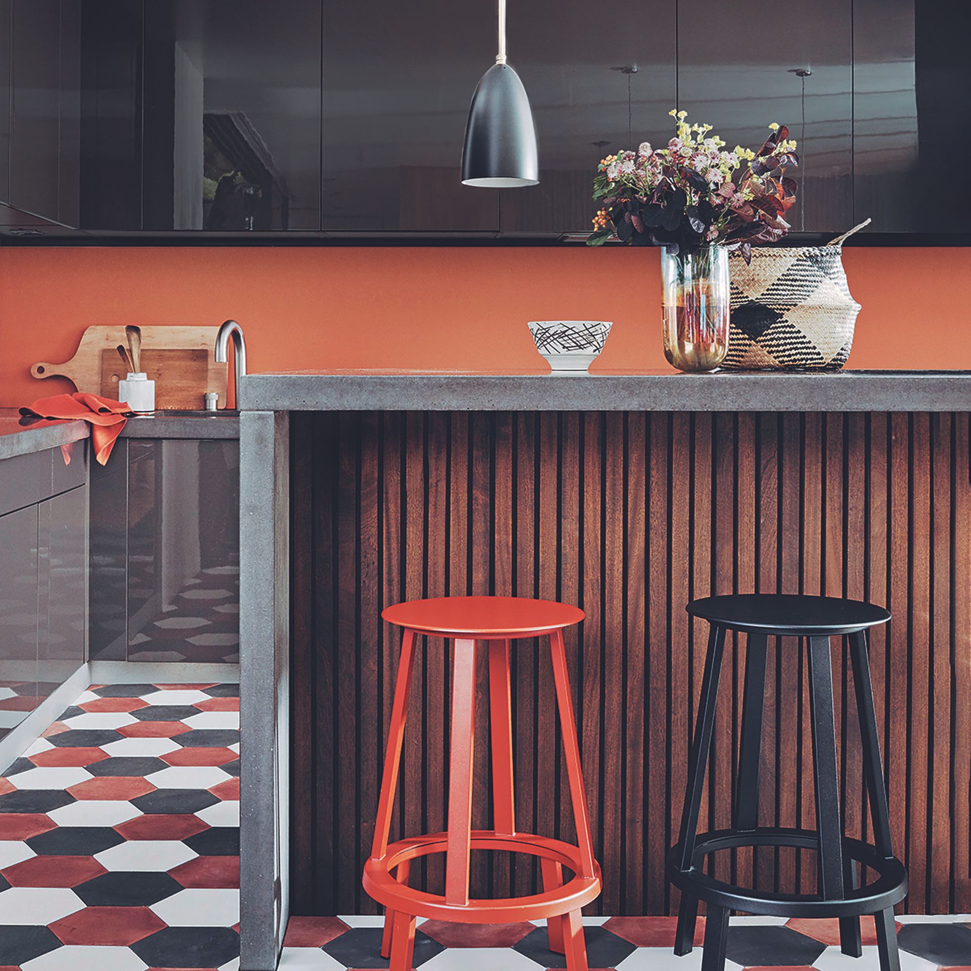 Terracotta kitchen backsplash with dark wood panelled island.