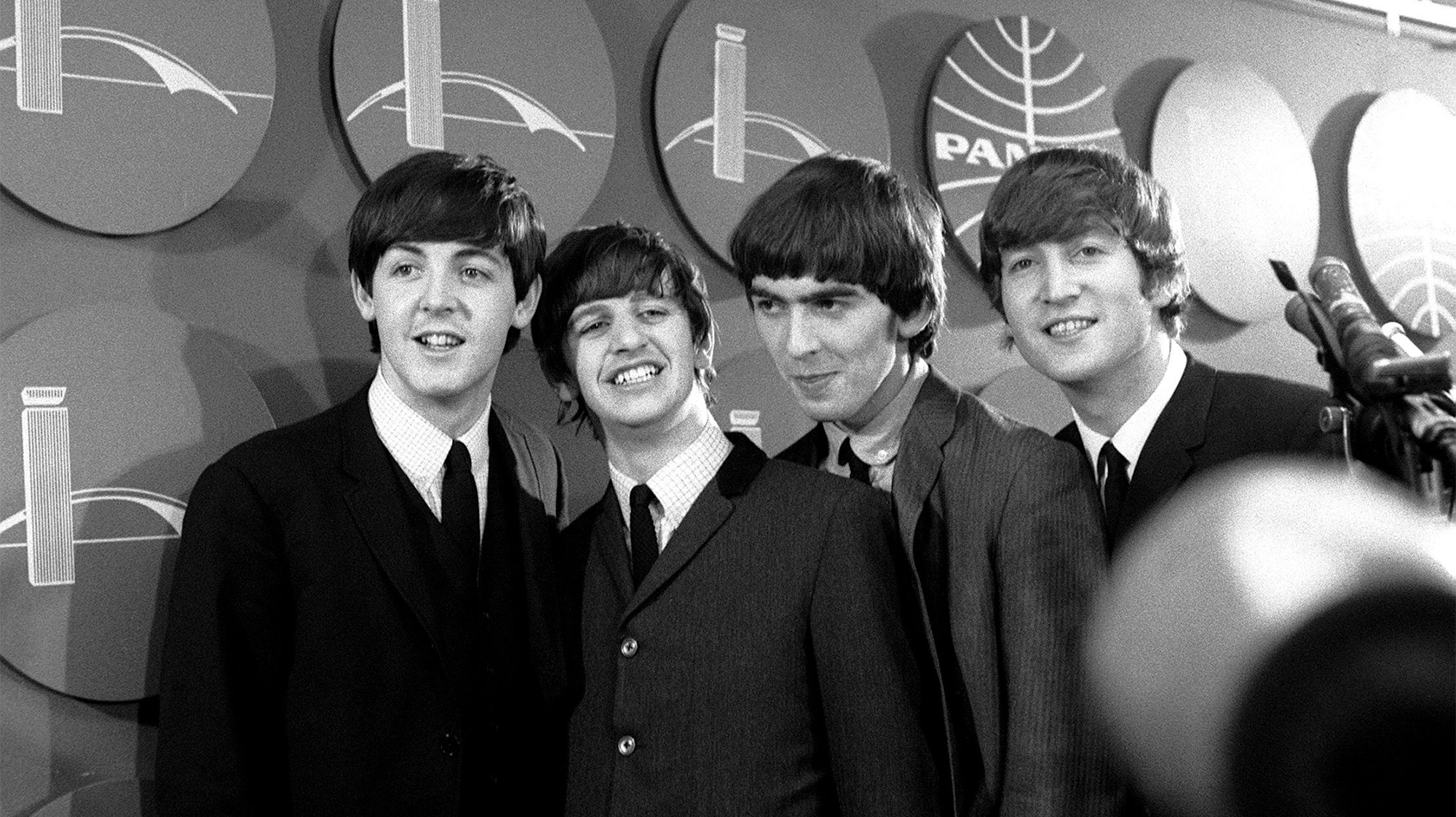 The Beatles answer questions for newsmen and journalists in New York after their arrival for their first tour of America. Left to right: Paul McCartney, Ringo Starr, George Harrison and John Lennon. 7th February 1964.